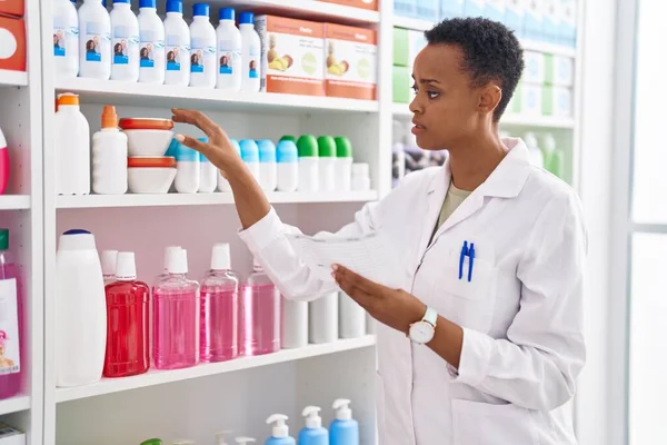 Африканская Американка Фармацевт Держит Бутылку Читая Рецепт Аптеке — стоковое фото