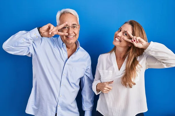 Medelåldern Latinamerikanskt Par Står Över Blå Bakgrund Gör Fred Symbol — Stockfoto