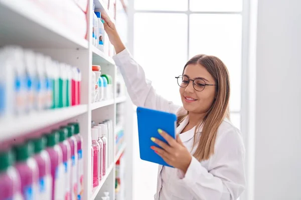 年轻美丽的惊慌失措的女药剂师在药店用触摸板拿着药 — 图库照片
