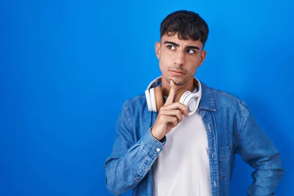 Junger Hispanischer Mann Der Vor Blauem Hintergrund Steht Und Konzentriert — Stockfoto