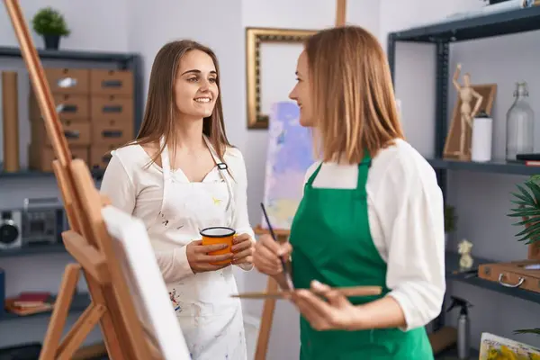 2人の女性アーティストがアートスタジオで自信を持ってコーヒーを飲む — ストック写真