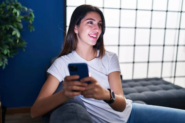 Evdeki Kanepede Oturan Akıllı Telefon Kullanan Genç Güzel Spanyol Kadın — Stok fotoğraf