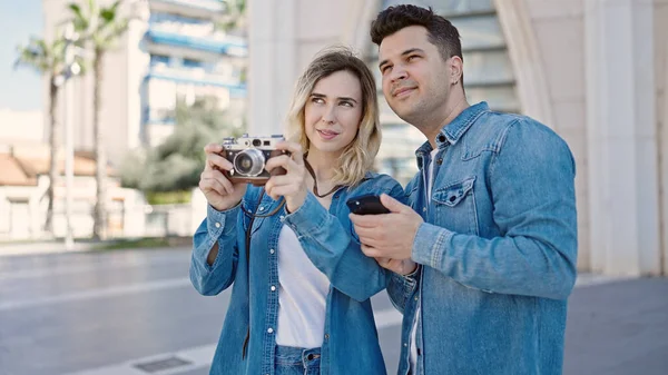 男と女のカップルが一緒に立ってカメラで写真を撮りますストリート — ストック写真