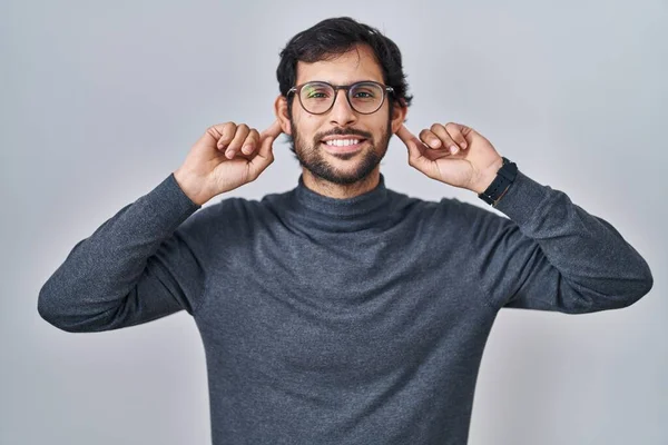 Handsome Latin Man Standing Isolated Background Smiling Pulling Ears Fingers — Stock Photo, Image