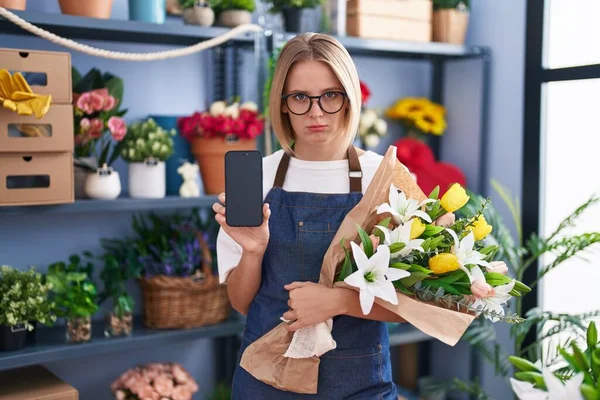 Młoda Biała Kobieta Pracująca Kwiaciarni Pokazuje Ekran Smartfona Przygnębiony Martwić — Zdjęcie stockowe