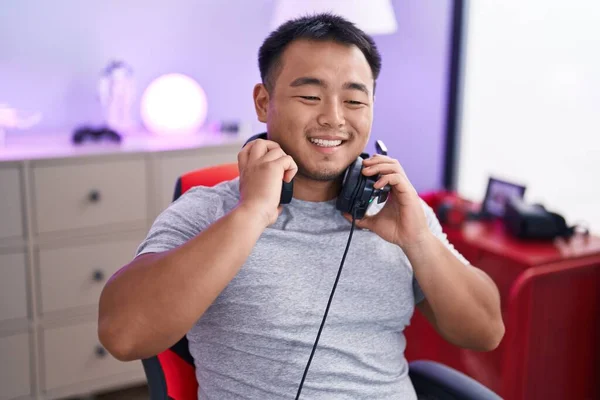 Young Chinese Man Streamer Smiling Confident Holding Headphones Gaming Room — ストック写真