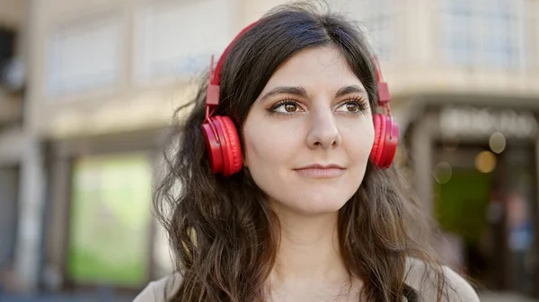 Jovem Bela Mulher Hispânica Ouvindo Música Com Expressão Séria Rua — Fotografia de Stock