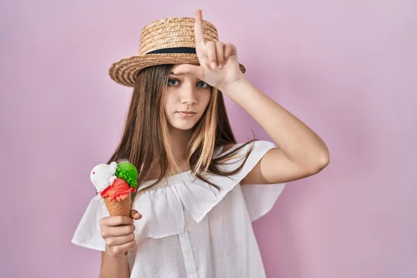 十代の女の子を保持していますアイスクリーム作り楽しいです人々とともに指オン額ド負け犬ジェスチャーモックと侮辱 — ストック写真