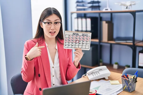 Chinese Young Woman Working Office Holding Holidays Calendar Pointing Finger — Stock Photo, Image