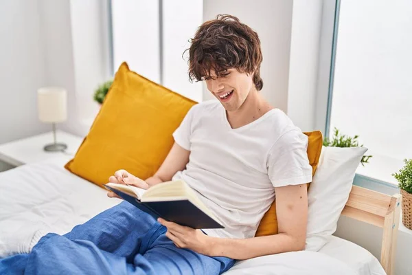 Young Hispanic Man Reading Book Sitting Bed Bedroom — Fotografia de Stock