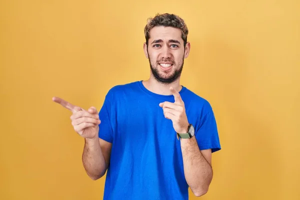 Hispanic Man Beard Standing Yellow Background Pointing Aside Worried Nervous — Stockfoto