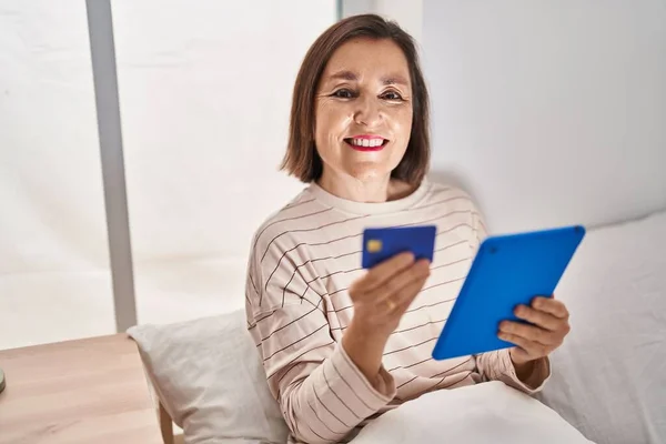 Middle Age Woman Using Touchpad Credit Card Sitting Bed Bedroom – stockfoto