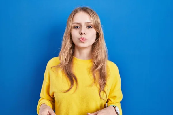 Mujer Joven Caucásica Pie Sobre Fondo Azul Hinchando Mejillas Con — Foto de Stock