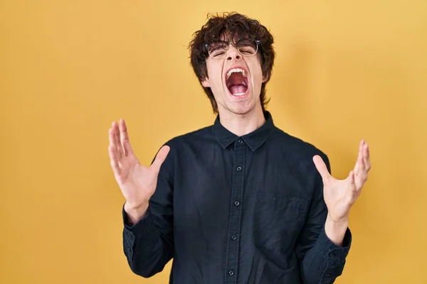 Mladý Muž Brýlemi Přes Žluté Pozadí Šílený Šílený Křičí Křičí — Stock fotografie