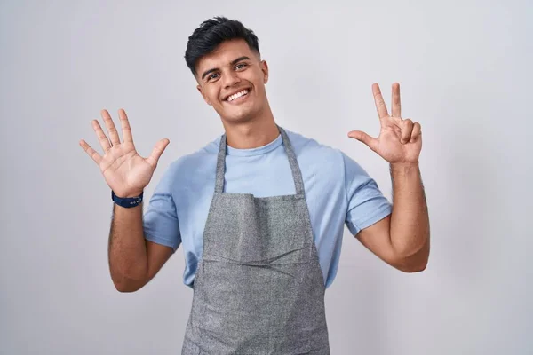 Hispanic Young Man Wearing Apron White Background Showing Pointing Fingers — Zdjęcie stockowe
