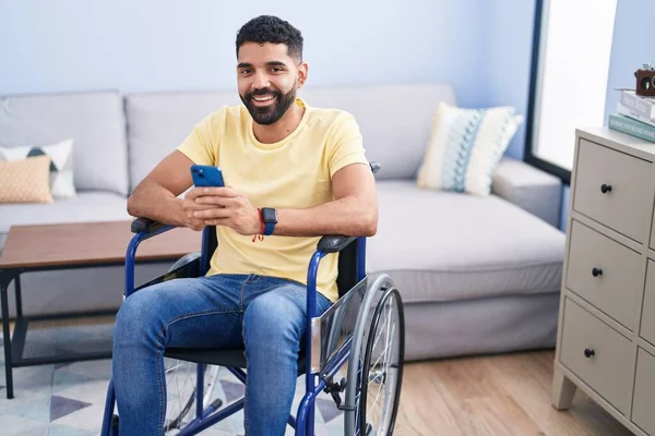 Jovem Árabe Homem Usando Smartphone Sentado Cadeira Rodas Casa — Fotografia de Stock
