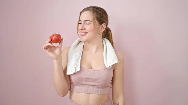 Ung Blond Kvinna Bär Sportkläder Håller Äpple Över Isolerad Rosa — Stockfoto
