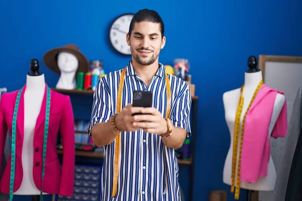 Young Hispanic Man Tailor Smiling Confident Using Smartphone Sewing Studio — Stockfoto