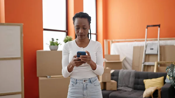 African American Woman Using Smartphone Standing New Home — Φωτογραφία Αρχείου