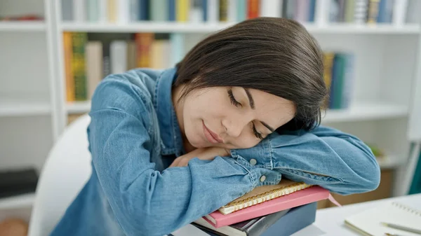 在大学教室里 年轻的高加索女学生把头靠在书本上睡觉 图库图片