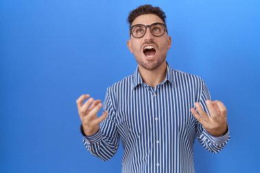 Sakallı, deli deli gözlüklü, saldırgan bir ifade ve kollarla bağıran İspanyol bir adam. hüsran kavramı. 