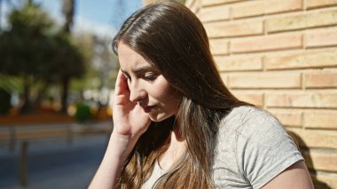 Sokağın ortasında üzgün bir ifadeyle duran genç, güzel İspanyol kadın.