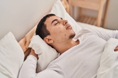 Young man lying on bed sleeping at bedroom