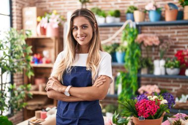 Young blonde woman florist smiling confident standing with arms crossed gesture at florist