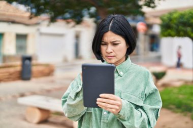 Young chinese woman using touchpad at park