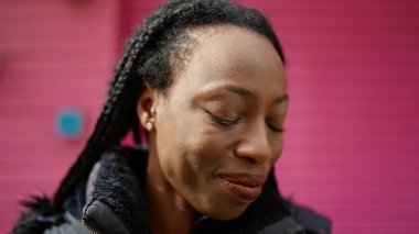 Sokakta kendine güvenen Afrikalı Amerikalı kadın gülümsüyor