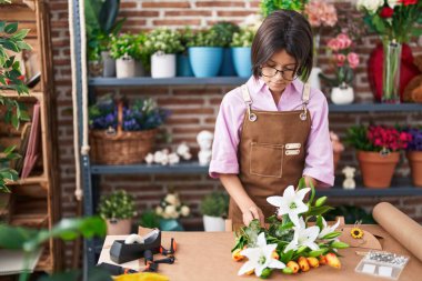 Sevimli İspanyol çiçekçi kız çiçekçide çiçek buketi yapıyor.