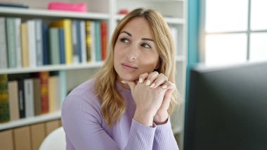 Kütüphanede bilgisayar kullanan genç ve güzel bir İspanyol kadın.