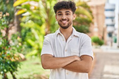 Young arab man smiling confident standing with arms crossed gesture at park