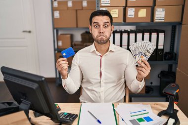 Küçük işletme şirketinde sakallı genç İspanyol bir adam elinde banknotlar ve komik suratıyla kredi kartı şişiren yanaklar tutuyordu. Ağzı havayla şişer, havayı yakalar.. 