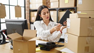 Genç, güzel, İspanyol bir kadın. İş kadını. Ofisteki dokunmatik kağıda yazıyor.