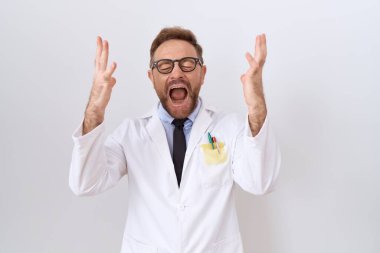 Middle age doctor man with beard wearing white coat celebrating mad and crazy for success with arms raised and closed eyes screaming excited. winner concept 