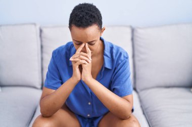 Afrikalı Amerikalı kadın evdeki kanepede otururken strese girdi.