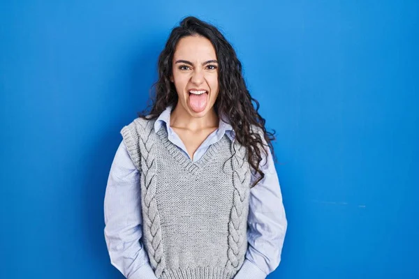 Mladá Bruneta Žena Stojící Nad Modrým Pozadím Vystrkující Jazyk Veselým — Stock fotografie