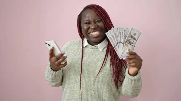 Afričanky Žena Copánky Úsměv Držení Peněz Smartphone Přes Izolované Růžové — Stock fotografie