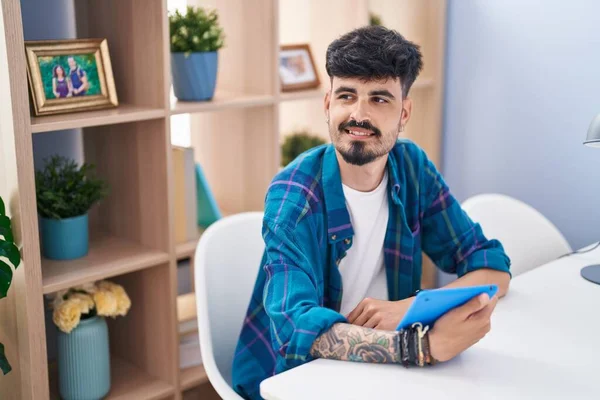 Young Hispanic Man Using Touchpad Sitting Table Home — Foto de Stock