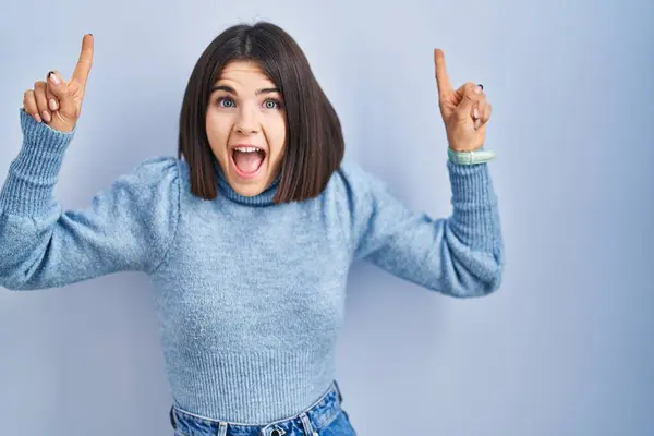 Joven Mujer Hispana Pie Sobre Fondo Azul Sonriendo Asombrada Sorprendida — Foto de Stock