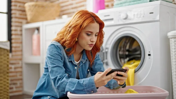 Νεαρή Κοκκινομάλλα Γυναίκα Πλένει Ρούχα Χρησιμοποιώντας Smartphone Στο Πλυσταριό — Φωτογραφία Αρχείου