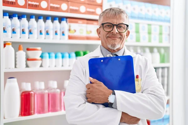 Middle Age Grey Haired Man Pharmacist Smiling Confident Hugging Clipboard — Stock Photo, Image