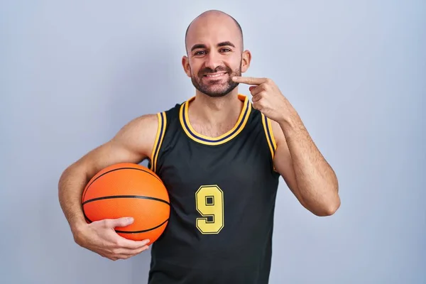 Fiatal Kopasz Szakállas Férfi Kosárlabda Egyenruhában Kezében Golyóval Vidáman Mosolyogva — Stock Fotó