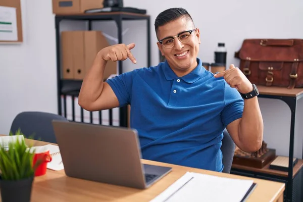 在办公室工作的年轻人 带着笔记本电脑 面带微笑 看上去很自信 用手指指着自己 自豪而快乐 — 图库照片