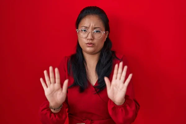 Asyalı Genç Bir Kadın Kırmızı Arka Planda Duruyor Avuçlarını Hareket — Stok fotoğraf