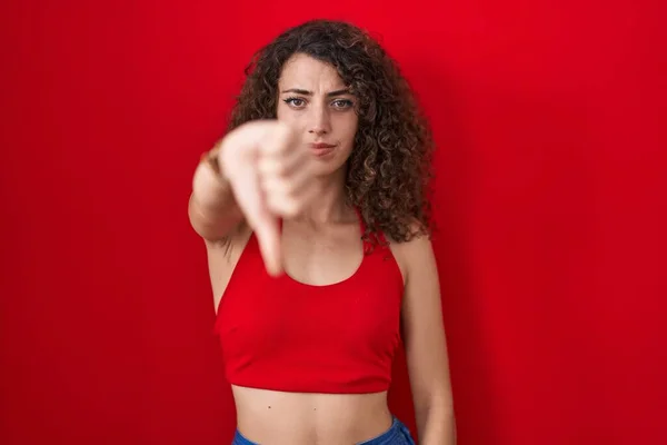 Hispanic Woman Curly Hair Standing Red Background Looking Unhappy Angry — Zdjęcie stockowe