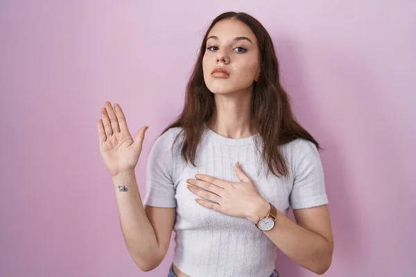 Menina Hispânica Jovem Sobre Fundo Rosa Jurando Com Mão Peito — Fotografia de Stock