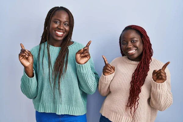 Deux Femmes Africaines Debout Sur Fond Bleu Souriant Confiant Pointant — Photo