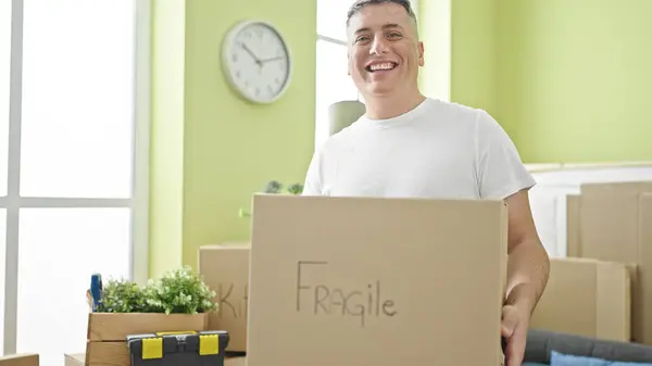 Młody Biały Mężczyzna Uśmiecha Się Pewnie Trzymając Delikatny Pakiet Nowym — Zdjęcie stockowe
